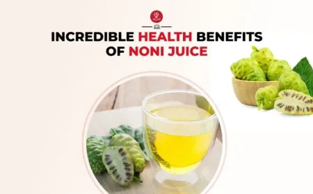 Glass of noni juice with fresh noni fruits and leaves