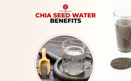 Glass of chia seed water with soaked chia seeds, lemon slices, and a healthy breakfast setup for wellness and hydration benefits.