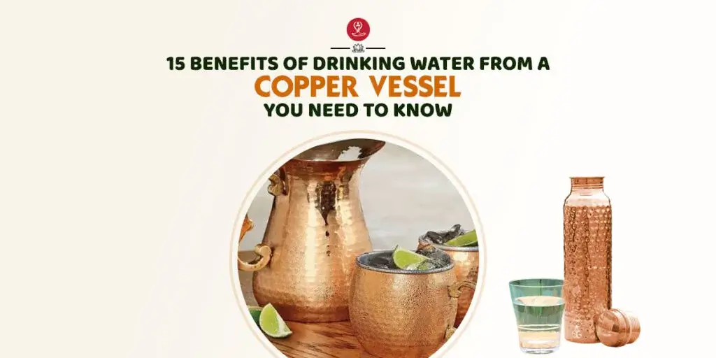 Copper water bottle beside a glass of water and healthy fruits