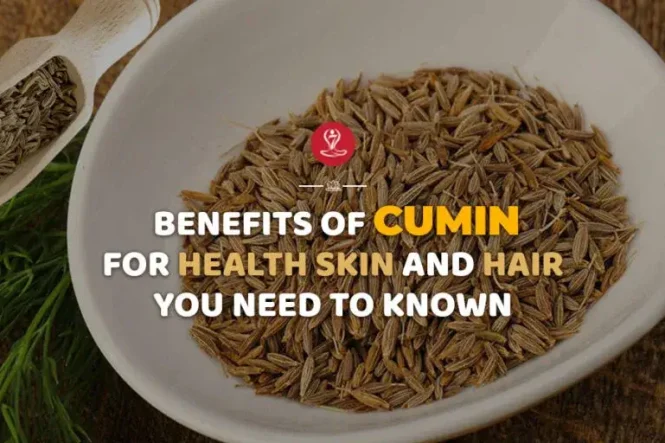 Wooden spoon filled with cumin seeds beside a glass of cumin water and fresh herbs, representing the health, digestion, metabolism, and skin benefits of cumin.